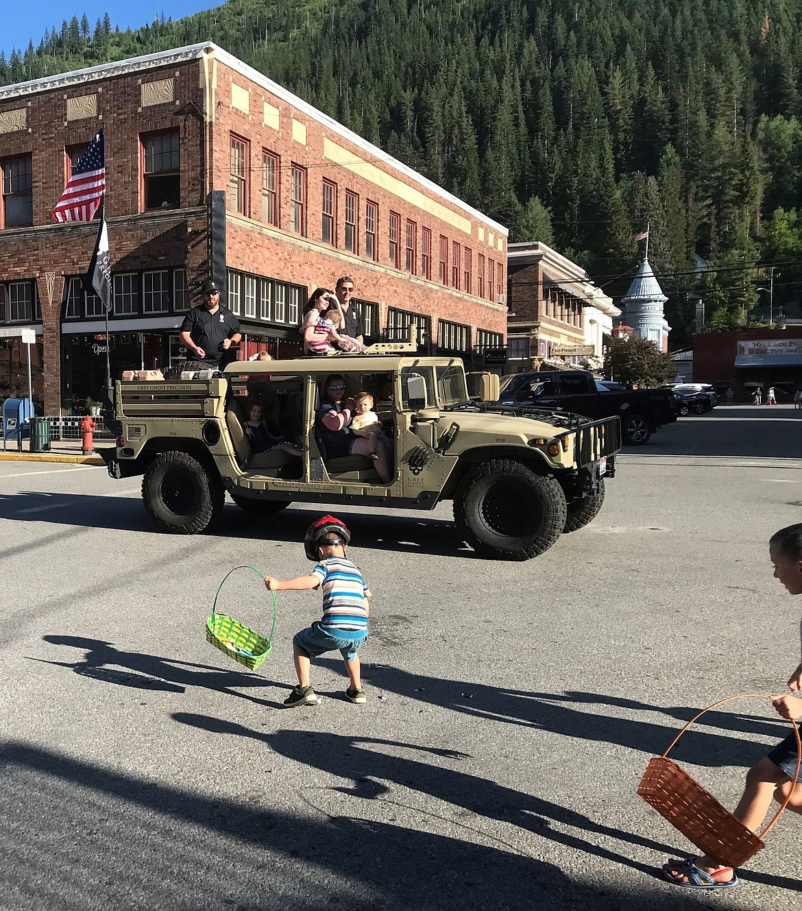 Grey Ghost Armory employees toss out candy to kids at the Wallace Statehood Day Parad.