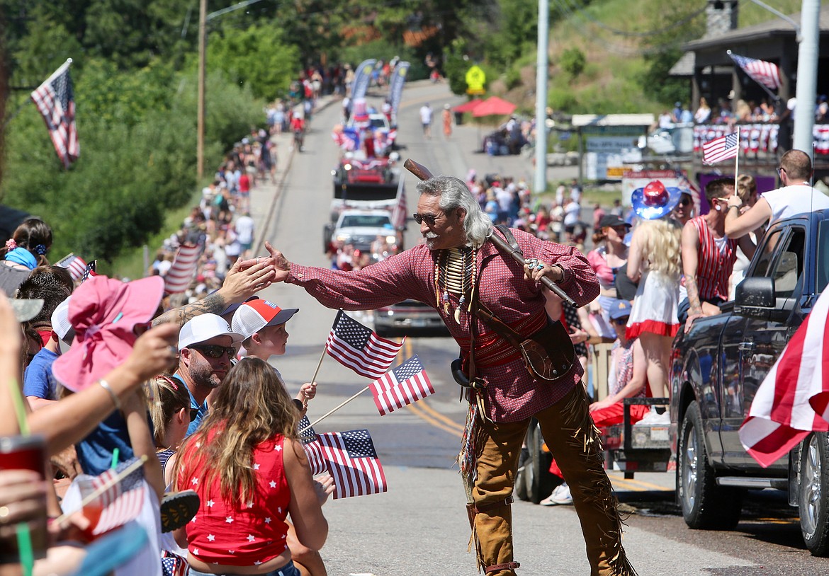 A parade participant greets attendees with high-fives during the annual Bigfork Fourth of July Parade. 
Mackenzie Reiss/Bigfork Eagle