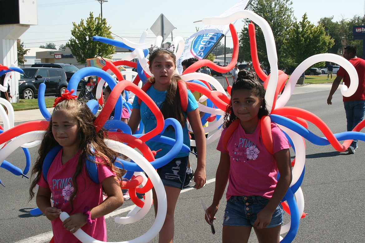 Festooned in patriotic balloons, participants march in the Independence Day parade in Othello Saturday.