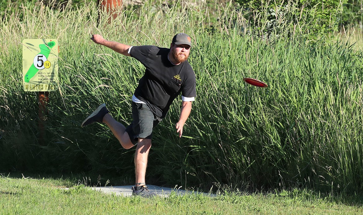 Kalen Kulp, who placed second on the men's side, tees off on hole No. 14 during Monday's Wampus Park disc golf tourney.