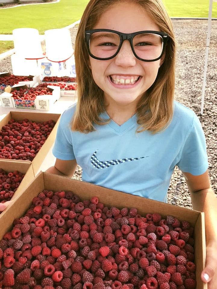 Brie Davis’ daughter Lindsey Davis holds a fresh raspberry harvest in the summer of 2018.