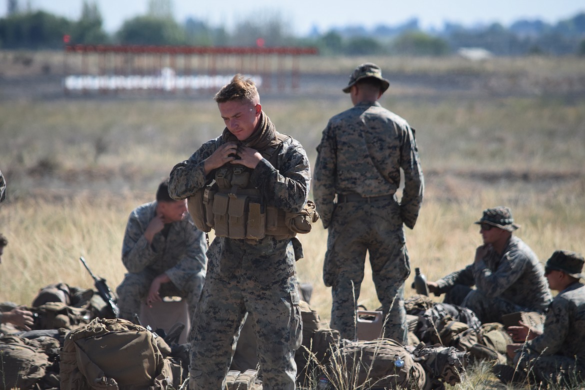 A group of Marine infantry troopers suit up Thursday morning in preparation to conduct a mock assault as part of a training exercise at the Grant County International Airport.