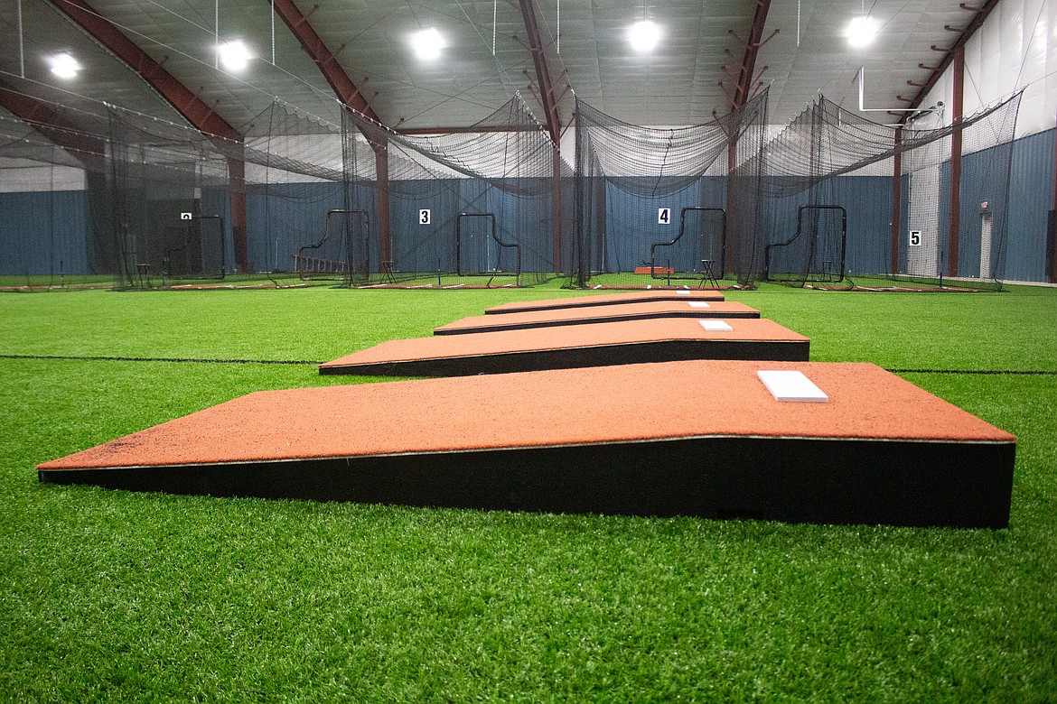 The light shines on the pitching mounds lining the turf in front of the batting cages at The Six Training Facility in Moses Lake.