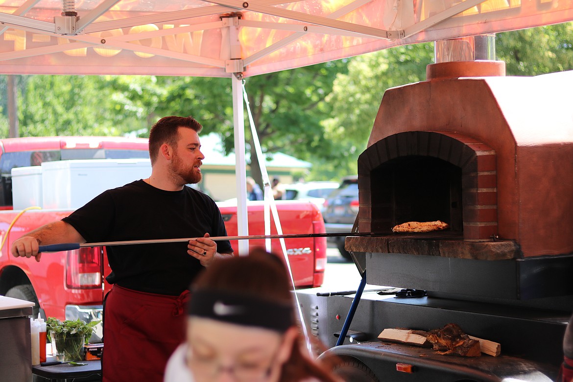 Tony Pivmarta pulls a Malvagio's wood-fired pizza out of the oven at the Post Falls Festival on Friday. HANNAH NEFF/Press