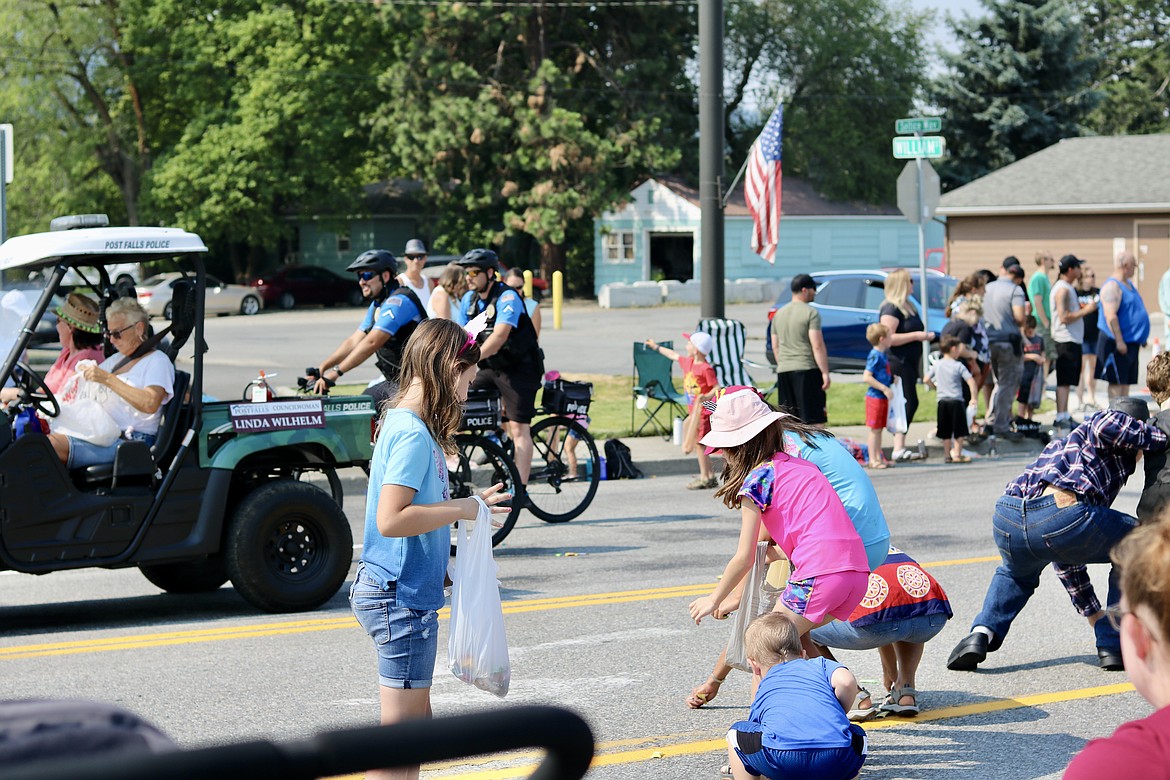 Kids rush into the streets to collect candy during Post Falls Festival parade on Seltice Way Saturday morning. HANNAH NEFF/Press