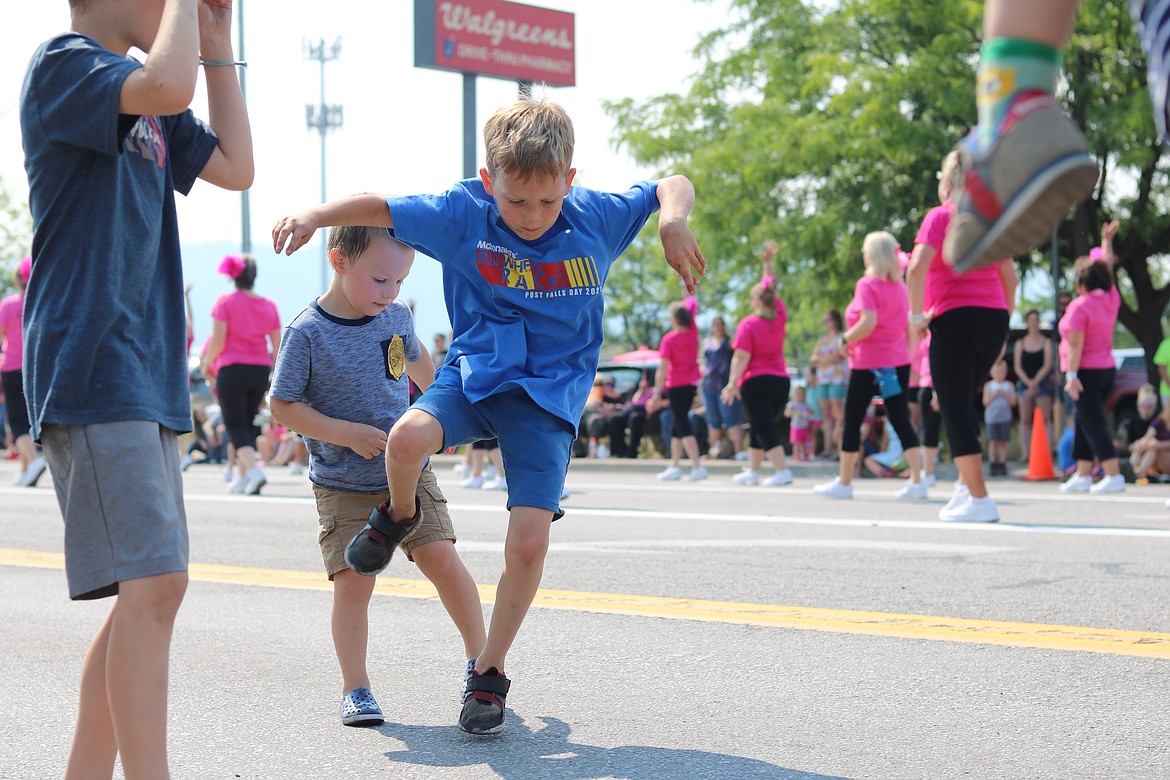 Levi Arnette, right, a 6 year old from Post Falls, dances along to the music from the Blazen Divaz joined by Samuel Putzey, 3, of Post Falls at the parade on Seltice Way Saturday morning. HANNAH NEFF/Press