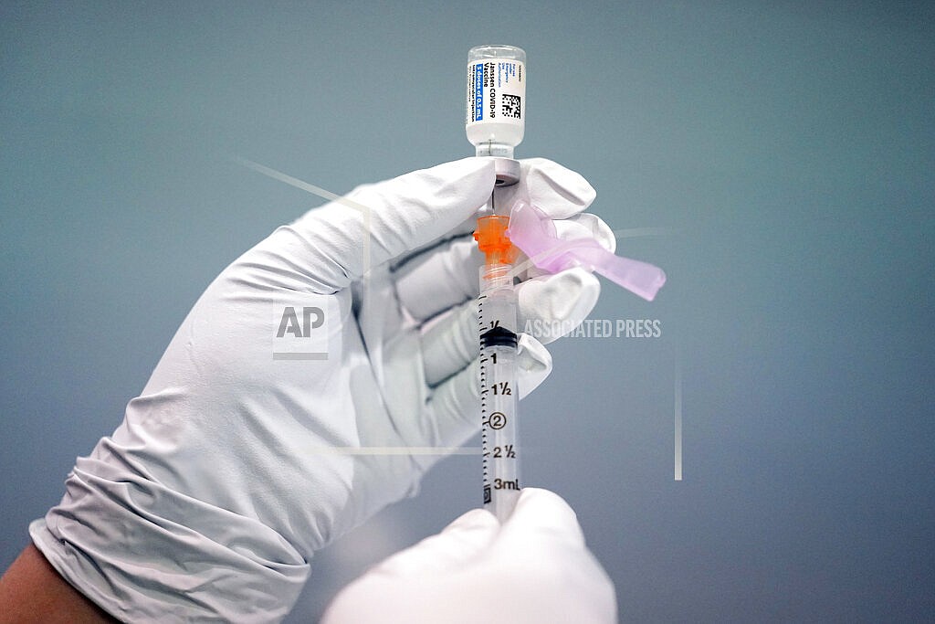 In this March 26, 2021, file photo a member of the Philadelphia Fire Department prepares a dose of the Johnson & Johnson COVID-19 vaccine at a vaccination site setup in Philadelphia. U.S. health officials say Johnson & Johnson’s COVID-19 vaccine may pose a “small possible risk” of a potentially dangerous neurological reaction. The Centers for Disease Control and Prevention said Monday, July 12 that it has received reports of 100 people who got the shot developing an immune system disorder that can causes muscle weakness and occasionally paralysis. (AP Photo/Matt Rourke, File)