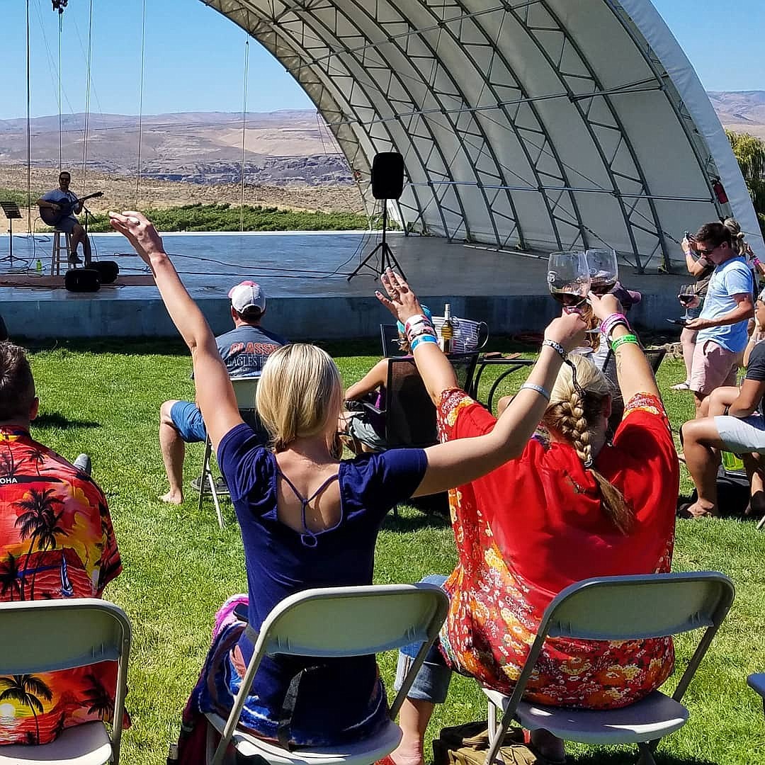 Audience members raise their glasses high at an open mic performance at Stage B.