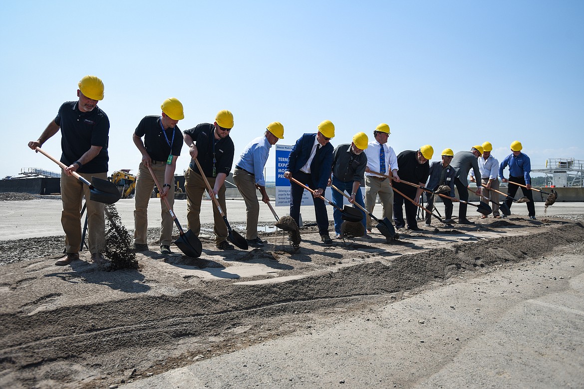 Dignitaries scoop up a shovel of dirt during a construction groundbreaking ceremony at Glacier Park International Airport in July 2021. The airport is embarking on a $100 million expansion that will nearly triple the current square footage of the facilities, taking GPIA from 75,000 to almost 200,000 square feet.(Casey Kreider/Daily Inter Lake file)