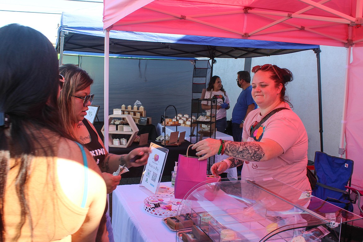 Judith Cisneros of JoJo’s Macarons sells a bag of goodies at the She Se Puede market on Sunday.