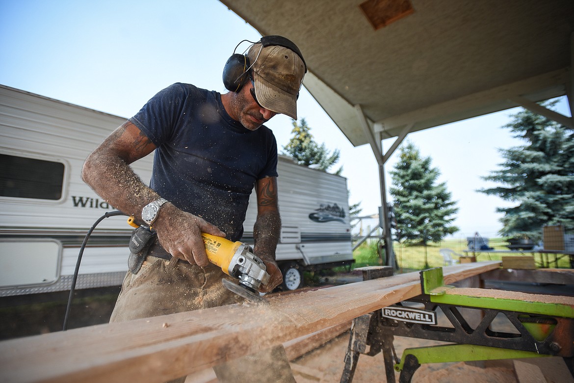 Course builder Louis Martin distresses pieces of wood used to make jumps for the cross-country course at Rebecca Farm on Thursday, July 15. (Casey Kreider/Daily Inter Lake)
