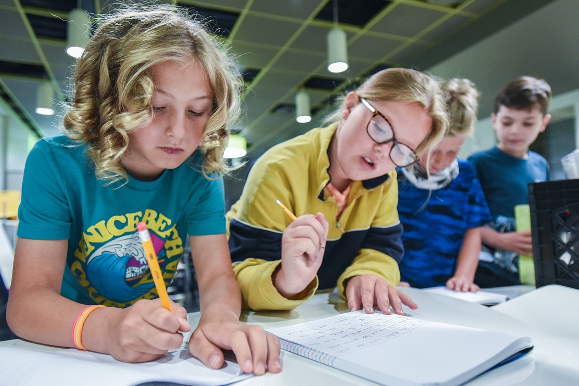 From left, incoming fourth-graders Elijah Walrath, River Knudsvig, Finn Irwin and Lucious Hatch work on a writing exercise during summer school at Muldown Elementary School in Whitefish on Tuesday, July 13. The students were given an abstract subject and asked to use adjectives and transitions to increase their writing stamina. (Casey Kreider/daily Inter Lake)