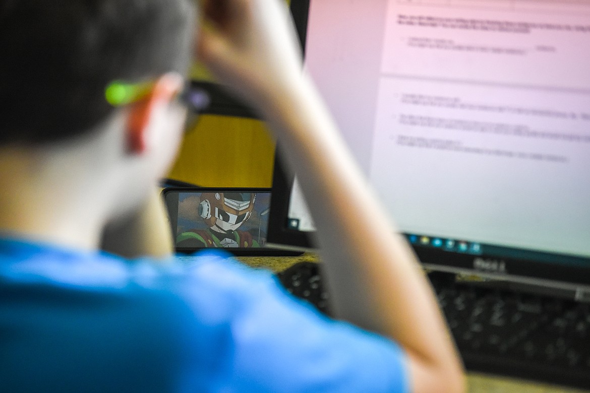 A student watches a video on his phone while working inside a lab during Kalispell Public Schools' high school summer school program at Glacier High School on Tuesday, July 14. (Casey Kreider/Daily Inter Lake)
