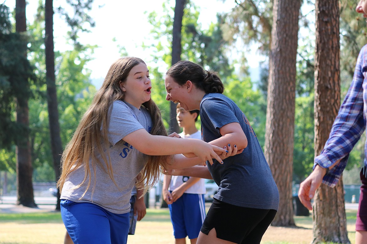 Jordyn Cord, left, and Madison Lowe, middle schoolers in the TRIO program, shriek while playing a game at the week-long environmental science field program in Q’emiln Park in Post Falls on Thursday. HANNAH NEFF/Press