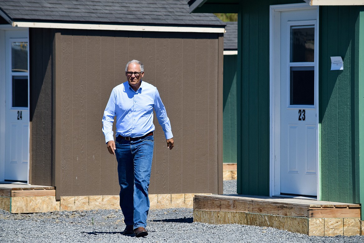Gov. Jay Inslee walks among the cabins of the Moses Lake Sleep Center during his tour on Thursday.