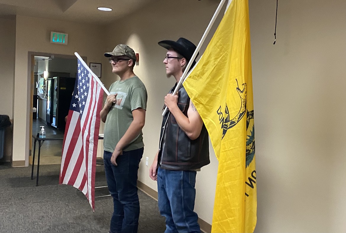 Audience members, nicknamed Tank, left, and Ghost, brought flags into the Optional Forms of Government study commission meeting Wednesday night to represent their political beliefs. (MADISON HARDY/Press)