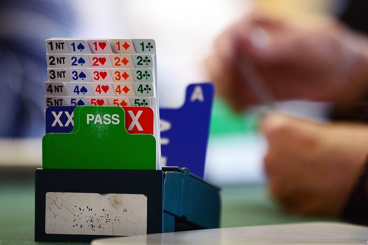 Bidding boxes are placed at the corner of the tabletop during a game of bridge at the Flathead Valley Bridge Center in Kalispell on Friday, March 6. Rather than bidding orally, bidding boxes are used to reduce noise in the room, prevent bids from being overheard at nearby tables, to allow easier review of the auction and to reduce the opportunity to pass  information to one's partner. (Casey Kreider/Daily Inter Lake)