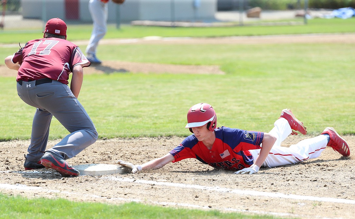 Alex Leverich slides back to first base to avoid being tagged out.