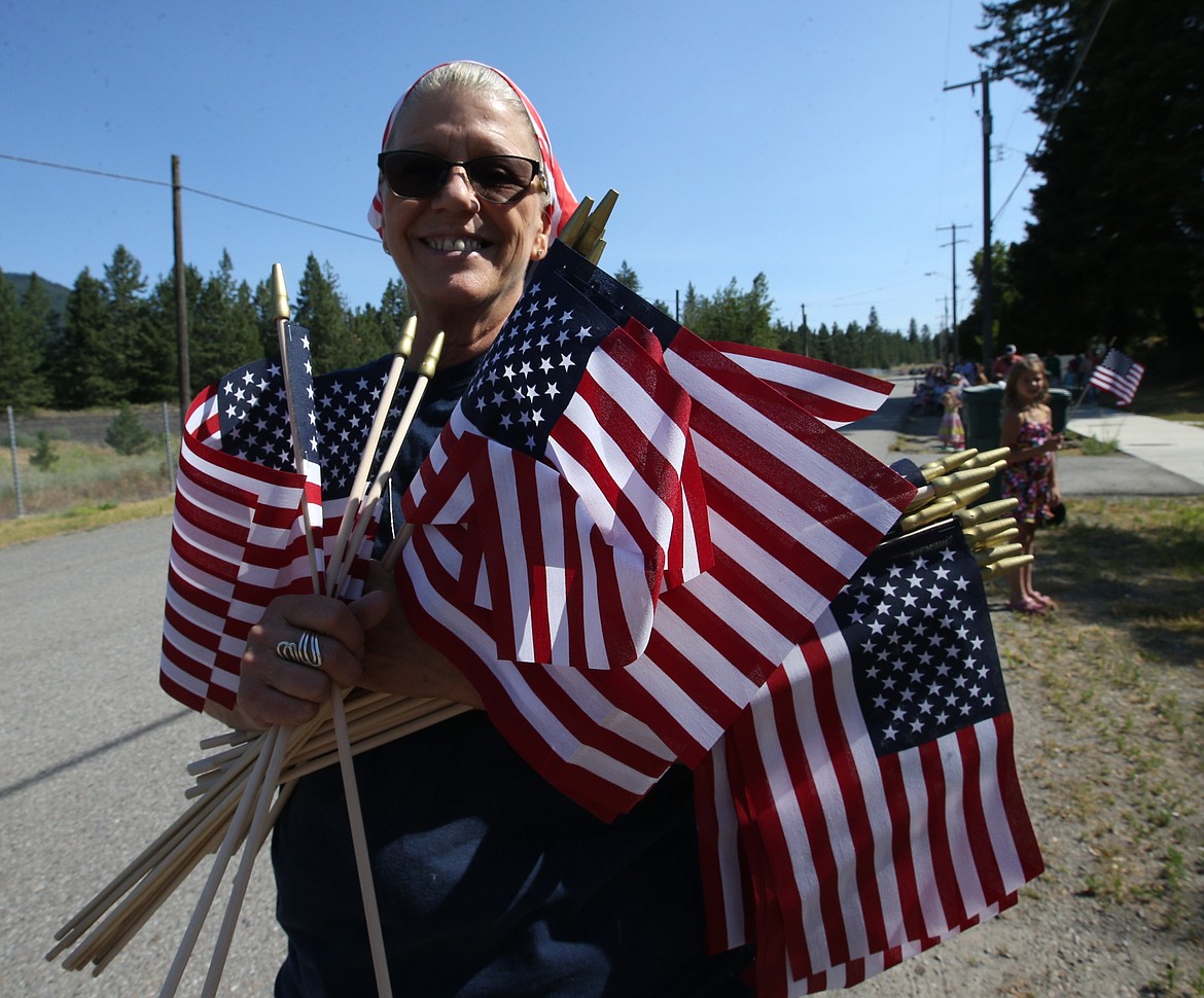 Rathdrum realtor Leslie Moug of Clearwater Properties handed out flags before the parade stepped off