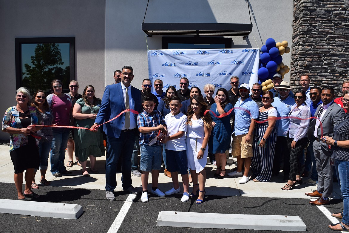 Jessie Dominguez, owner of Othello-based Imagine Realty Group, along with his wife Amy and their sons Elijah and Noah, as well as employees and representatives from the Moses Lake Chamber of Commerce, cut the ribbon at the formal grand opening of the Moses Lake office on Friday.