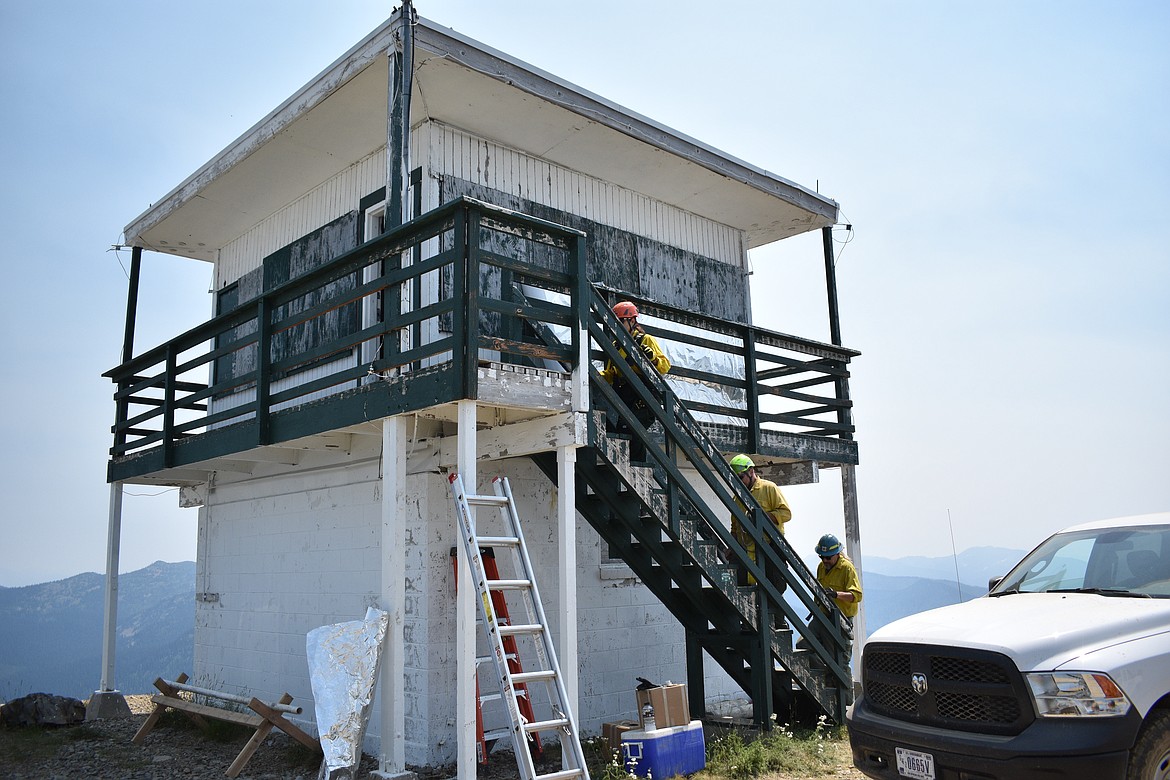 Crews walk up the stairs to begin wrapping the Lunch Peak Lookout on Saturday.