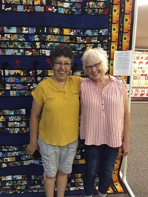 Sandra Cortes-Medina (left) and Karen Ertz (right), winners of the 2021 Royal City Summerfest Quilt Show, stand before Cortes-Medina’s winning quilt.
