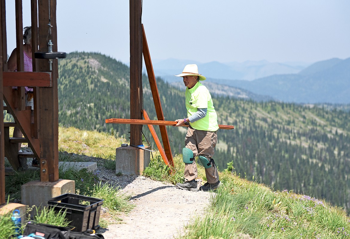 Northwest Montana Lookout Association volunteer project leader Rick Davis works to replace decking boards at the Werner Peak Lookout during a recent restoration project. (Whitney England/Whitefish Pilot)