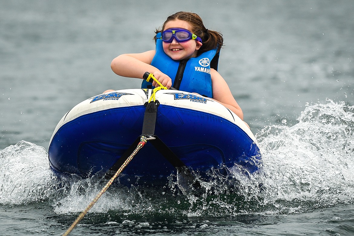 Gracie Jones, of Kalispell, flashes a smile as she rides an inflatable EZ-Ski around Echo Lake during DREAM Adaptive's Water Sports Program on Tuesday, July 20. (Casey Kreider/Daily Inter Lake)