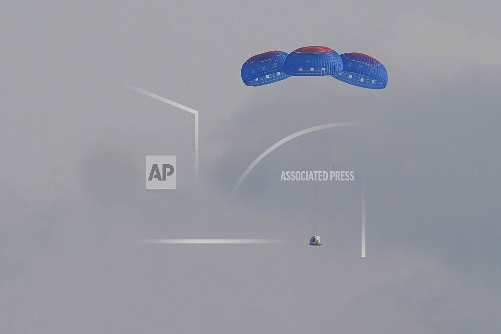 Blue Origin's New Shepard capsule parachutes safely down to the launch area with passengers Jeff Bezos, founder of Amazon and space tourism company Blue Origin, brother Mark Bezos, Oliver Daemen and Wally Funk, near Van Horn, Texas, Tuesday, July 20, 2021. (AP Photo/Tony Gutierrez)