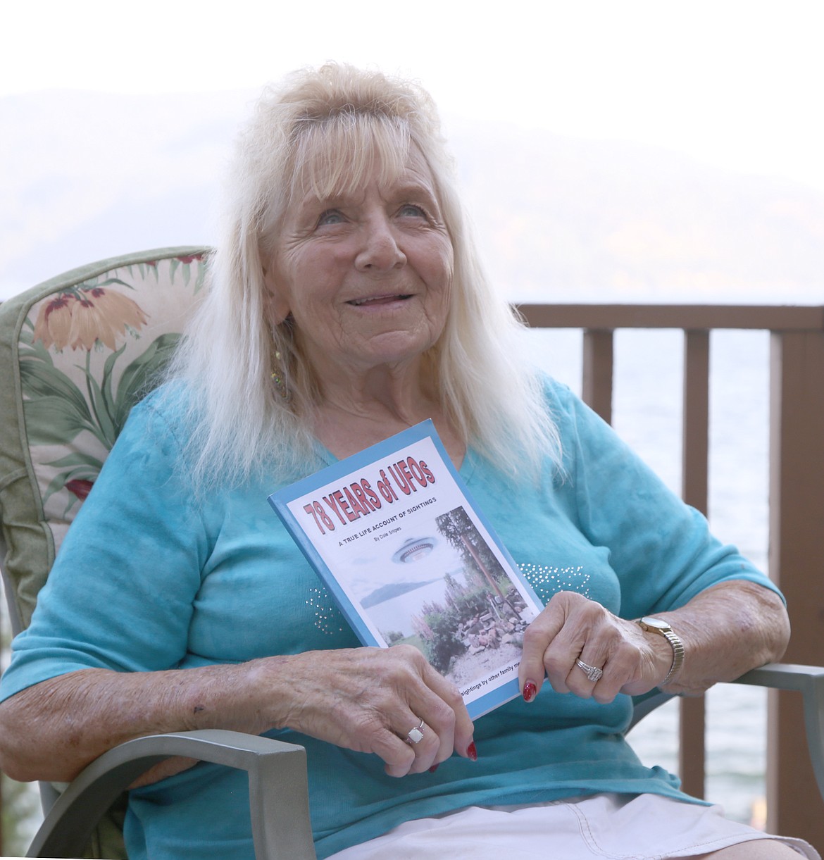 Dale Snipes, author of "78 Years of UFOs" sits on her porch at her home on Lake Pend Oreille. Snipes accounts unexplainable phenomena in her ninth publication. A couple of the sightings mentioned in the book were witnessed from the porch pictured.