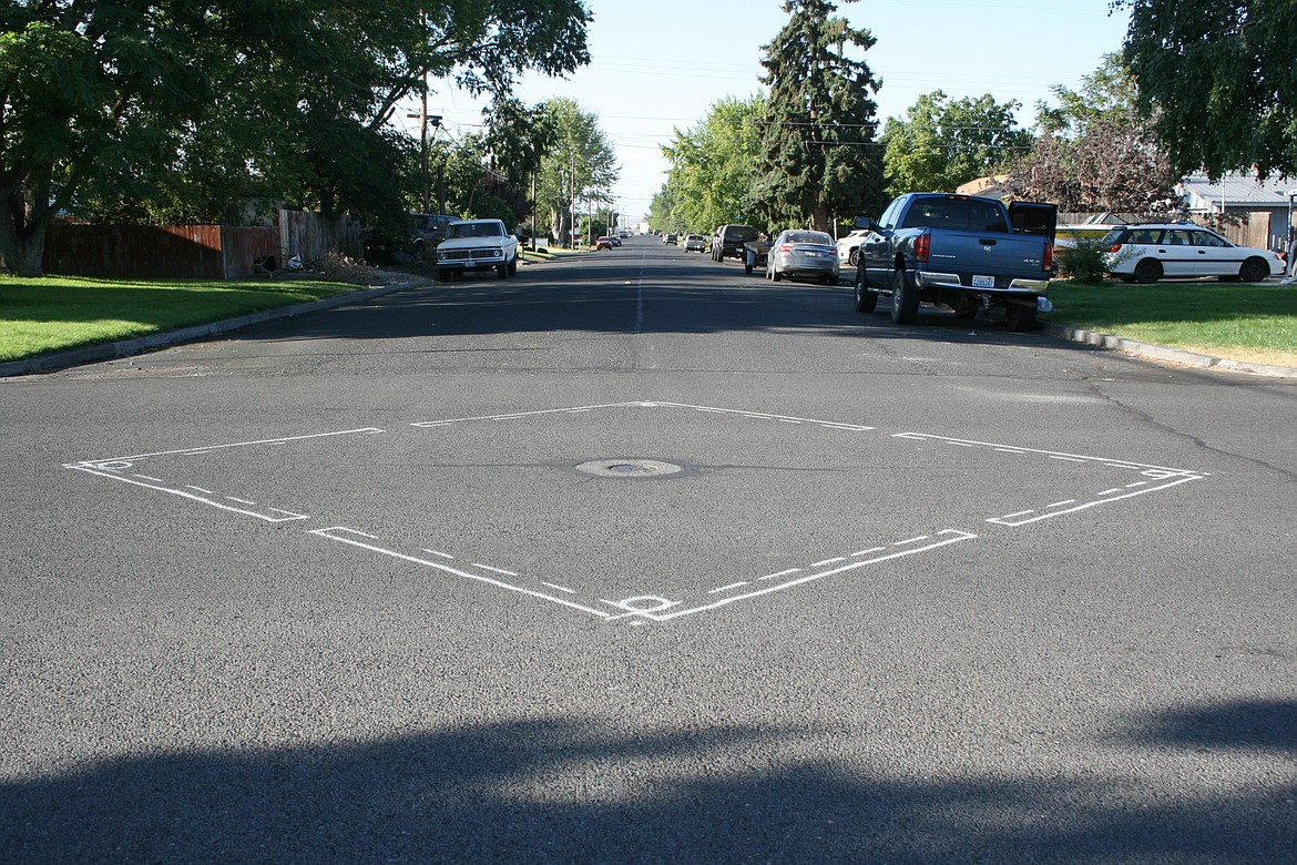 Paint outlines where a demonstration roundabout, in a diamond shape, will be installed at the intersection of Eighth Avenue and Hemlock Street as part of a project to find methods to slow down traffic in residential neighborhoods.