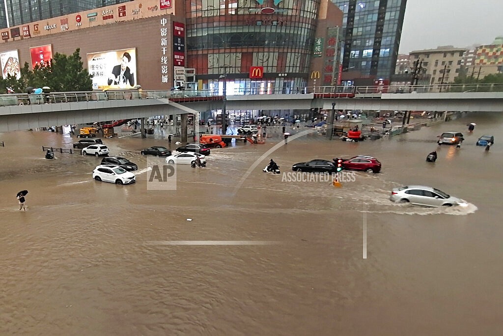 Vehicles are stranded after a heavy downpour in Zhengzhou city, central China's Henan province on Tuesday, July 20, 2021. Heavy flooding has hit central China following unusually heavy rains, with the subway system in the city of Zhengzhou inundated with rushing water. (Chinatopix Via AP)