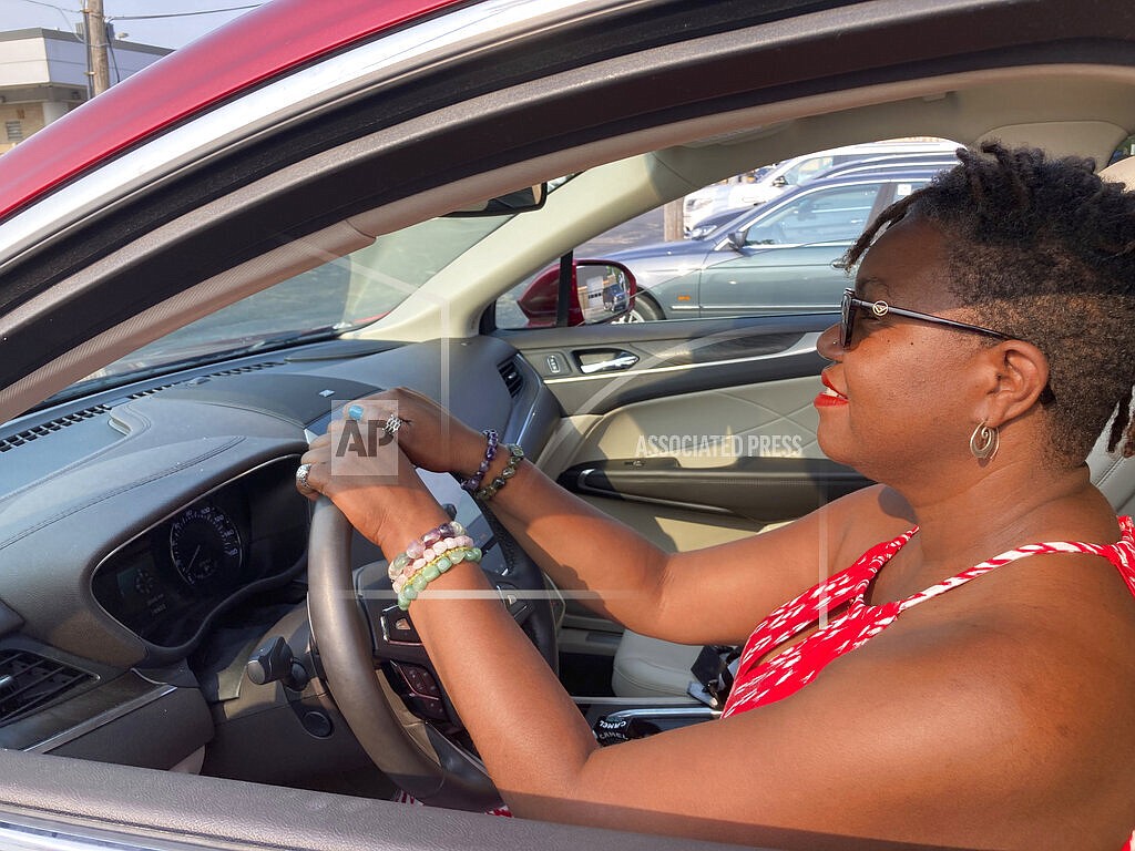 Jessica Pitts sits behind the wheel of a 2019 Lincoln MKC on the lot of Jack Demmer Lincoln in Dearborn, Mich., on Monday, July 19, 2021. Pitts bought the used car at the dealership. A seemingly endless streak of skyrocketing used vehicle prices is finally coming to a close in the U.S., according to the latest data (AP Photo/Mike Householder)