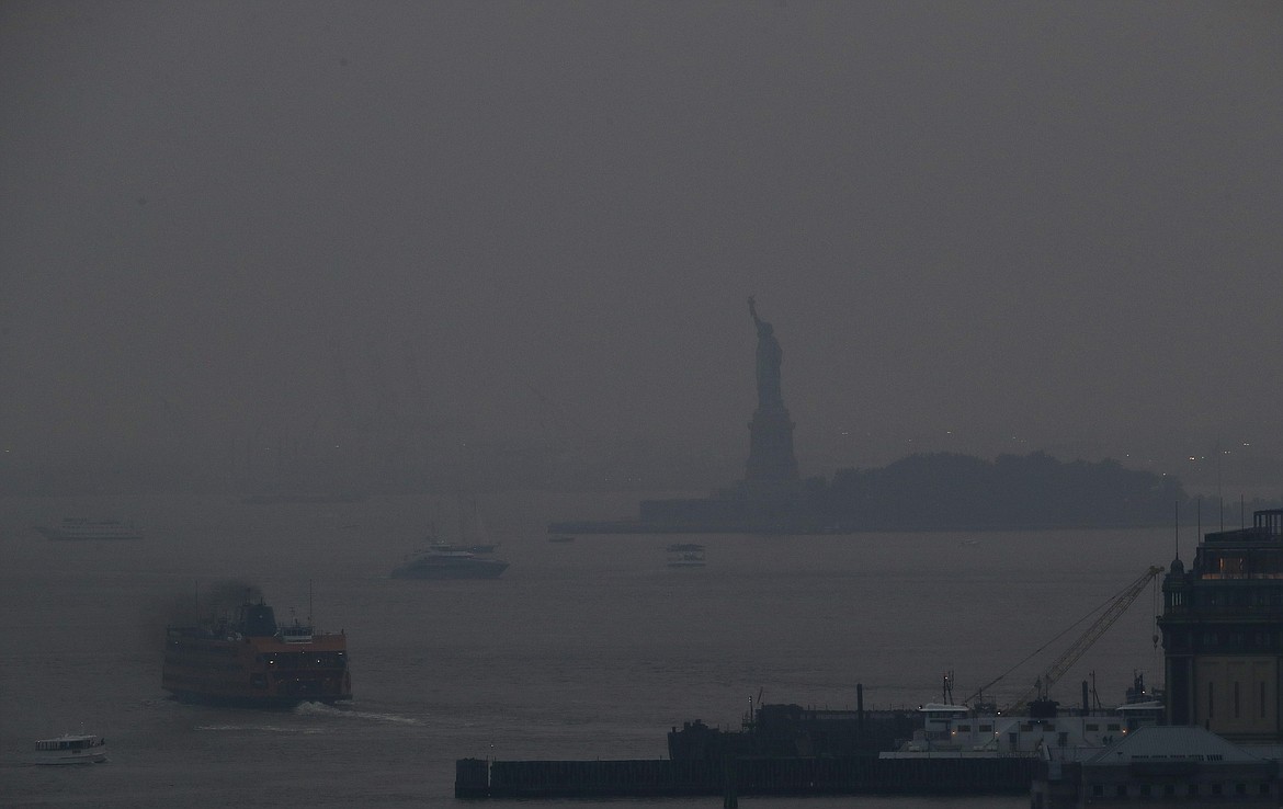 The Staten Island Ferry departs from the Manhattan terminal through a haze of smoke with the Statue of Liberty barely visible on Tuesday, July 20, 2021, in New York. Wildfires in the American West, including one burning in Oregon that's currently the largest in the United States, are creating hazy skies as far away as New York as the massive infernos spew smoke and ash into the air in columns up to 6 miles high. (Julie Jacobson/Associated Press)