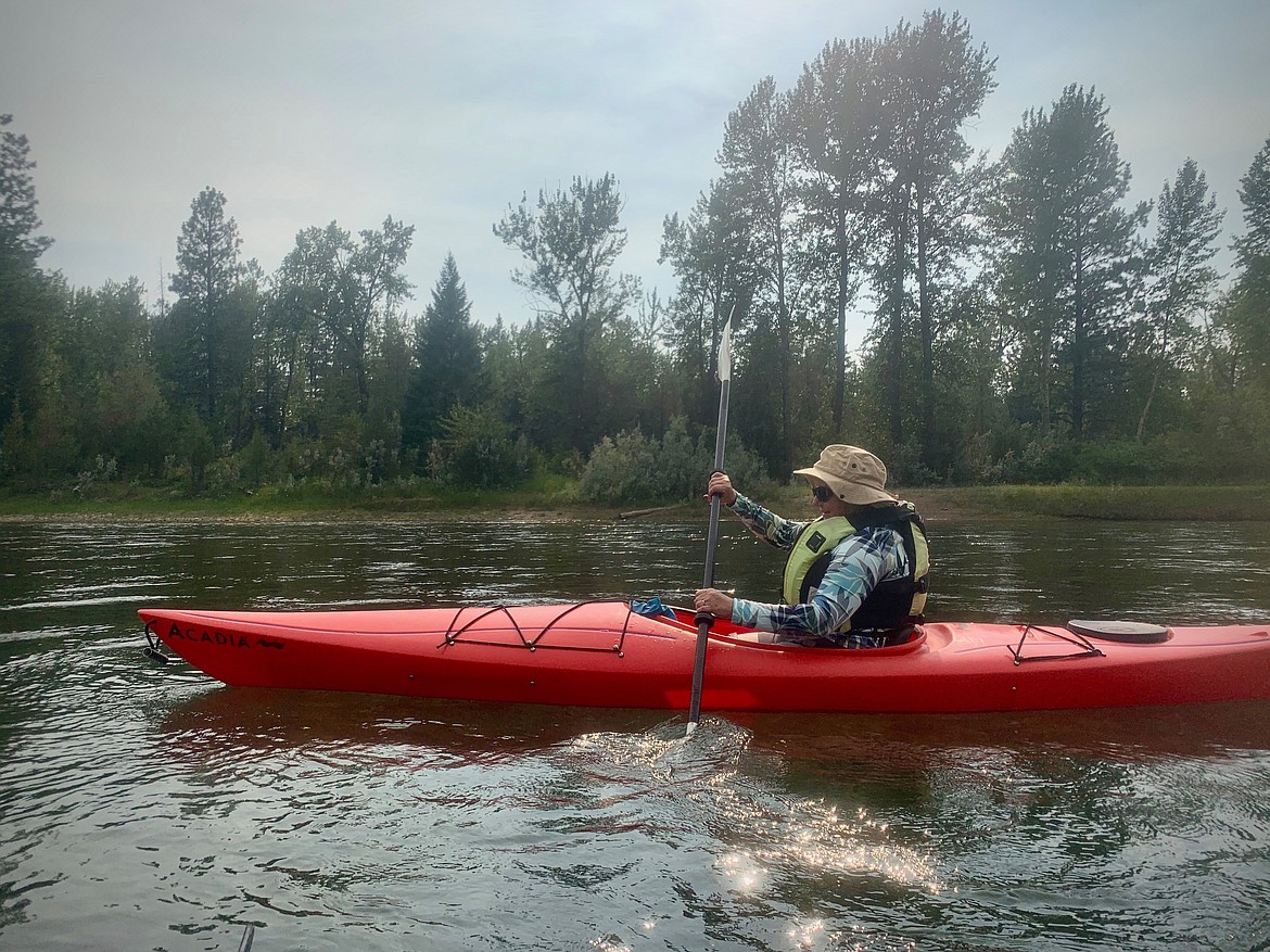 A kayaker paddles along the Flathead River en route to the Old Steel Bridge fishing access site in Evergreen on Friday, July 16, 2021. (Mackenzie Reiss/Daily Inter Lake)