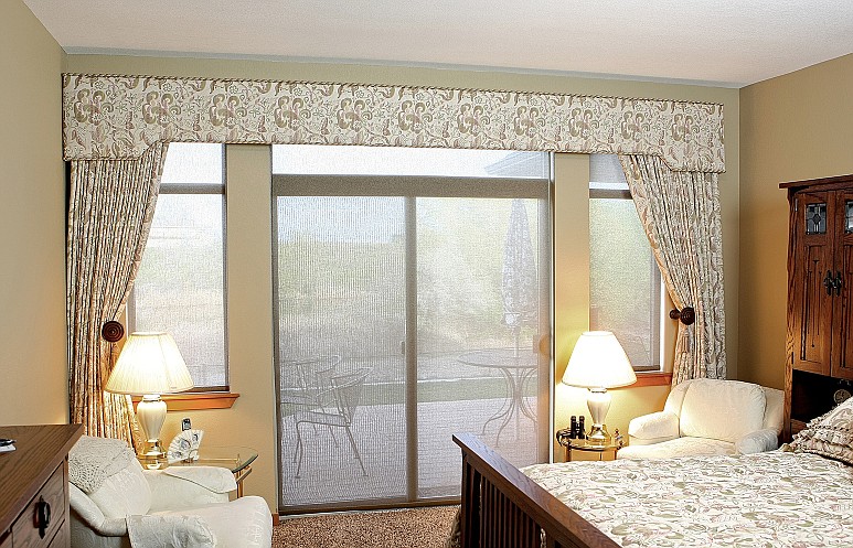 Custom matching bedspread and drapery is a popular choice for customers and can even be paired with solar shades or other window shade options pictured here.