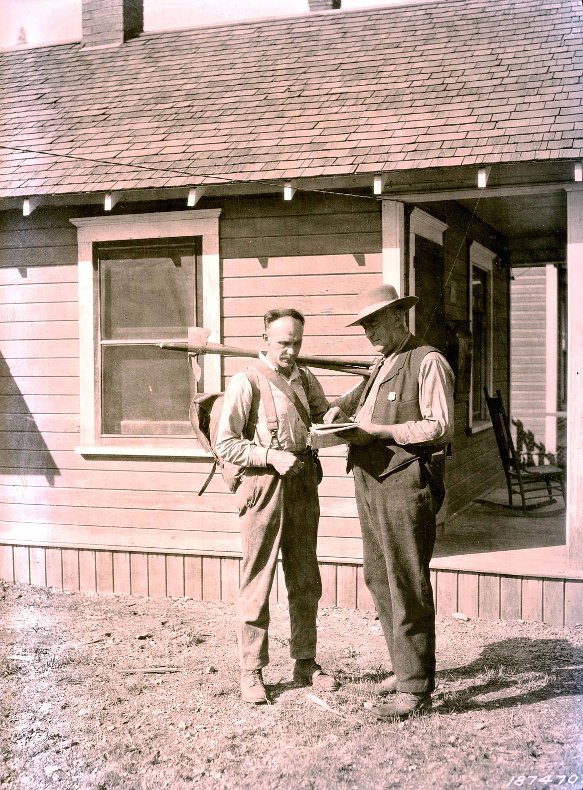 Two men in Wallace, one with firefighting equipment.