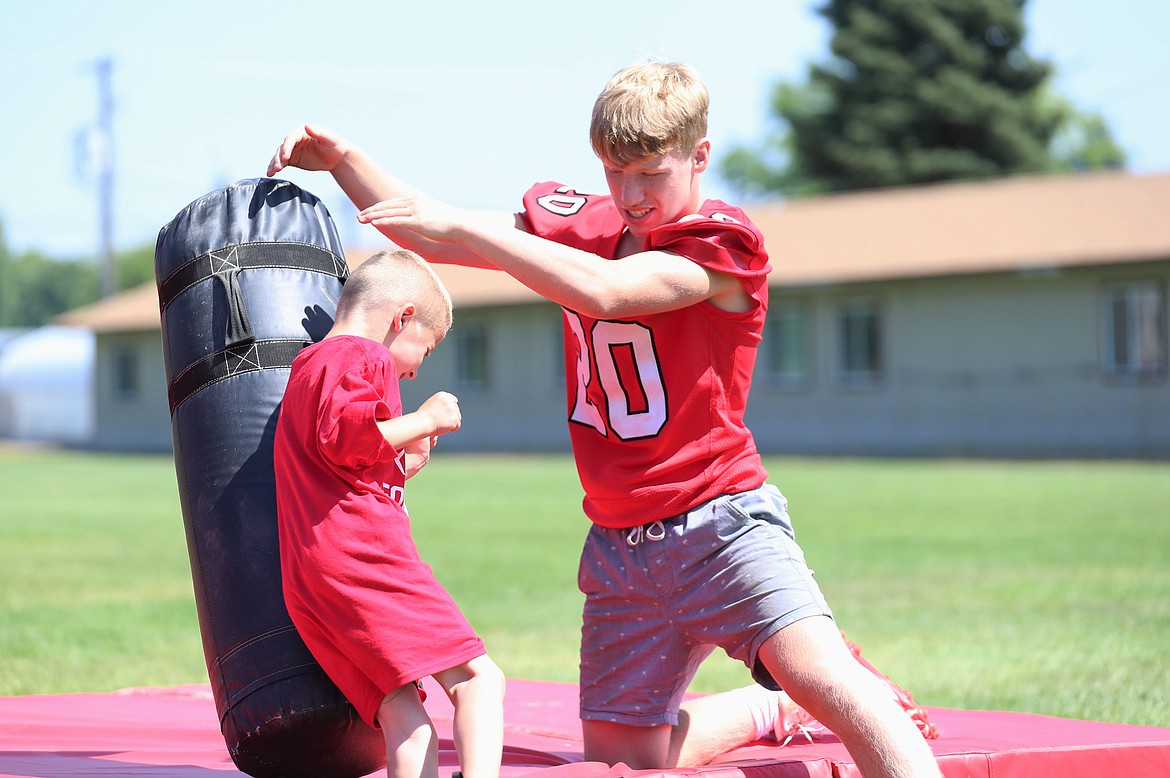 Shane Sherrill holds the bag for a camper during tackling drills on Friday.