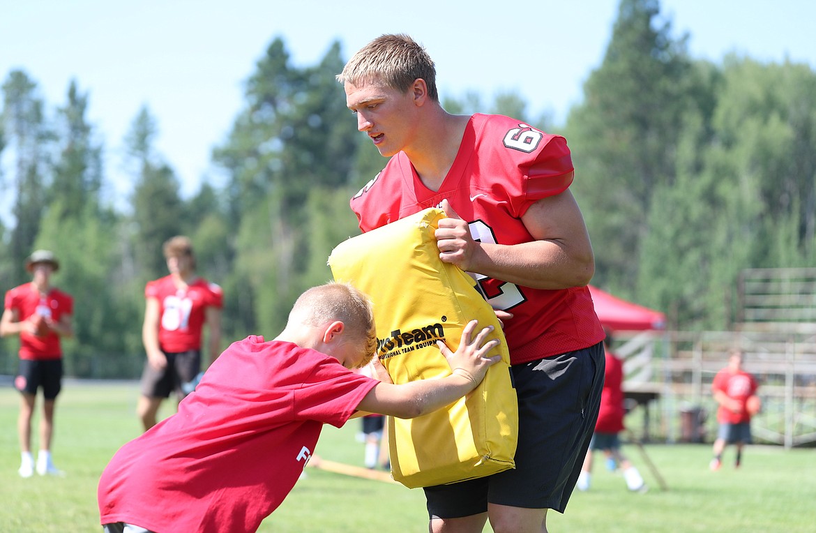 Mike Chapman helps campers with their offensive line skills on Friday.