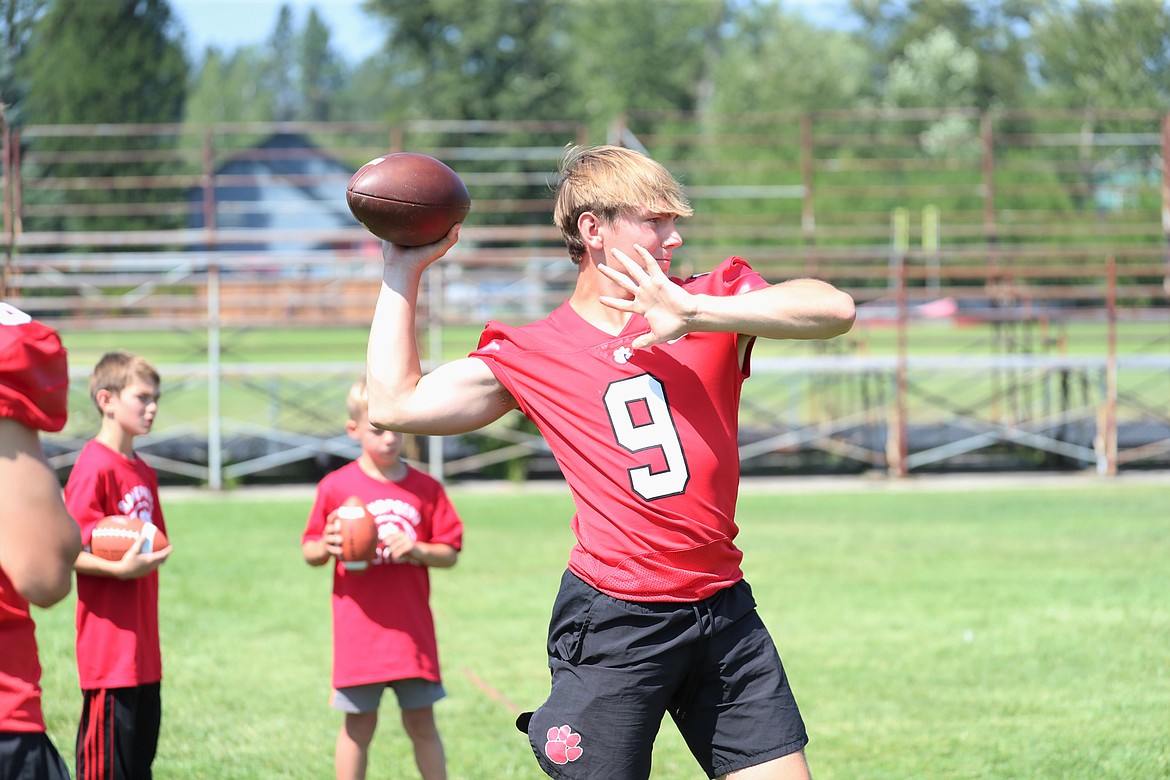 Parker Pettit demonstrates a quarterback drill for the campers on Friday.