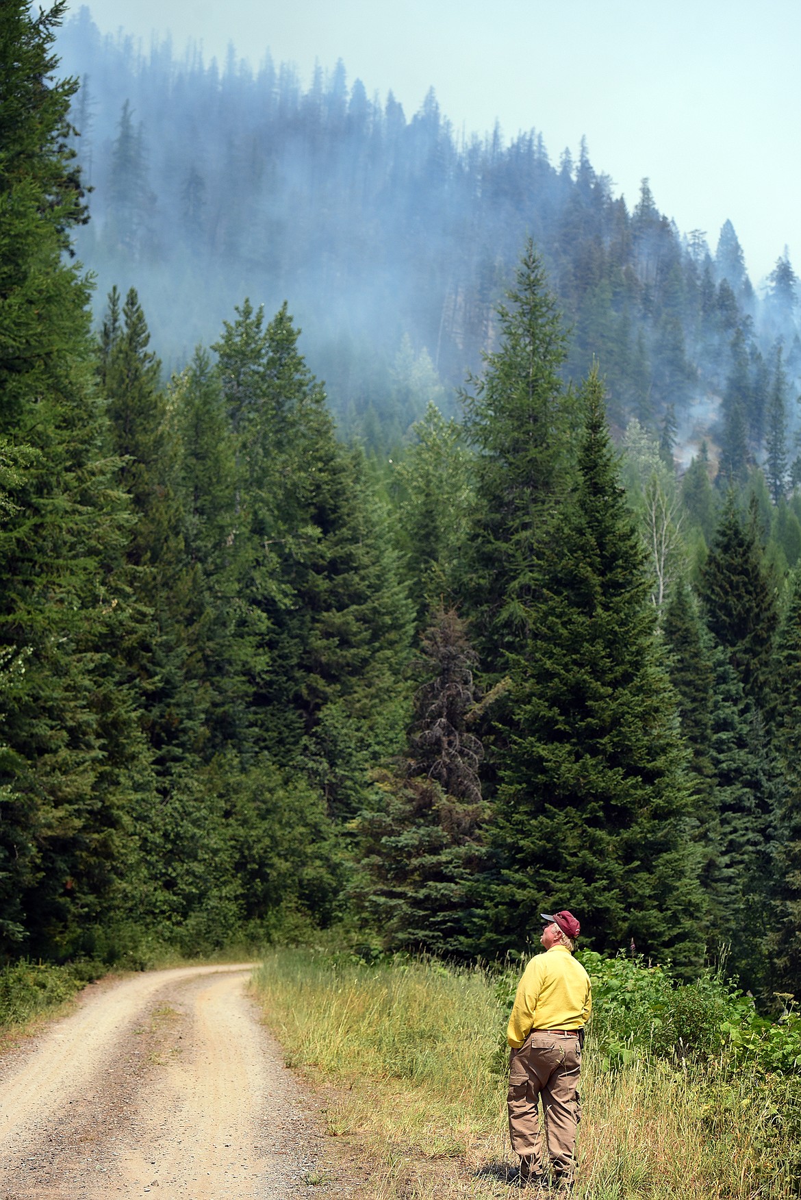 Fire Safety Officer Rick Trembath observes the Hay Creek Fire near Polebridge Saturday. Steep terrain has made battling the fire difficult. (Jeremy Weber/Daily Inter Lake)