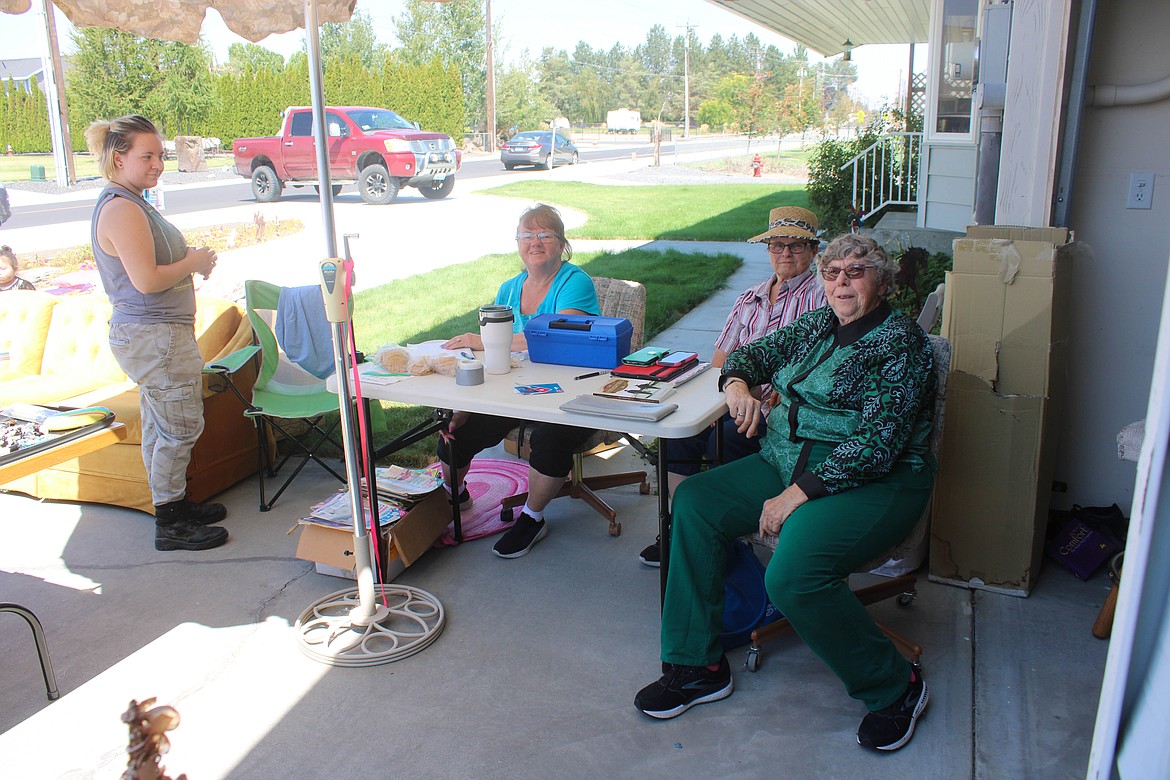 Left to right: volunteers Max Isaacson, Carry Liles, Irene Waters and Rosie Sonnichsen catch some shade by the register at the Serve Moses Lake garage sale fundraiser on Saturday.