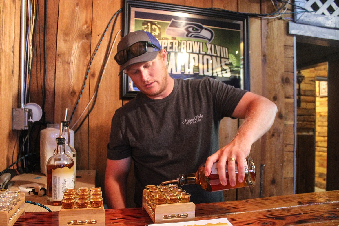 Moses Lake Distillery owner Zachary Hughes pours his wheated bourbon at Midway Pub in Moses Lake on Saturday.