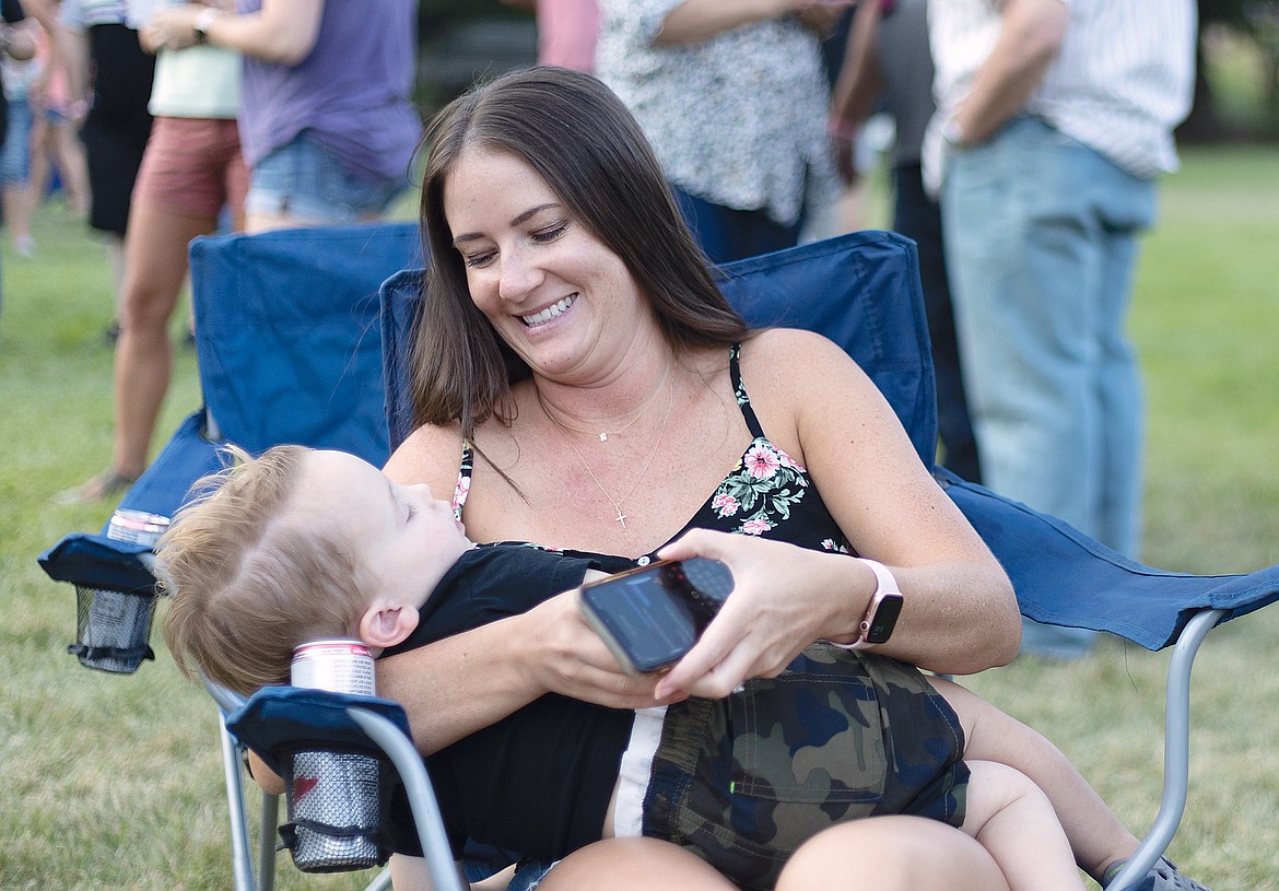 Danielle Fields looks over son J.J. who fell asleep during the Wildcat Endowment Auction Friday.