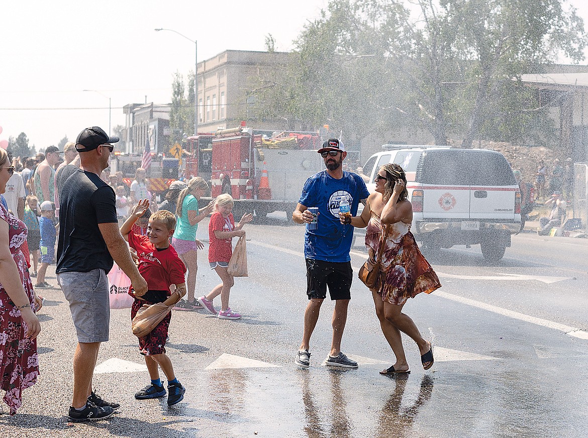 Revelers cool off from the spray of fire trucks during the parade.