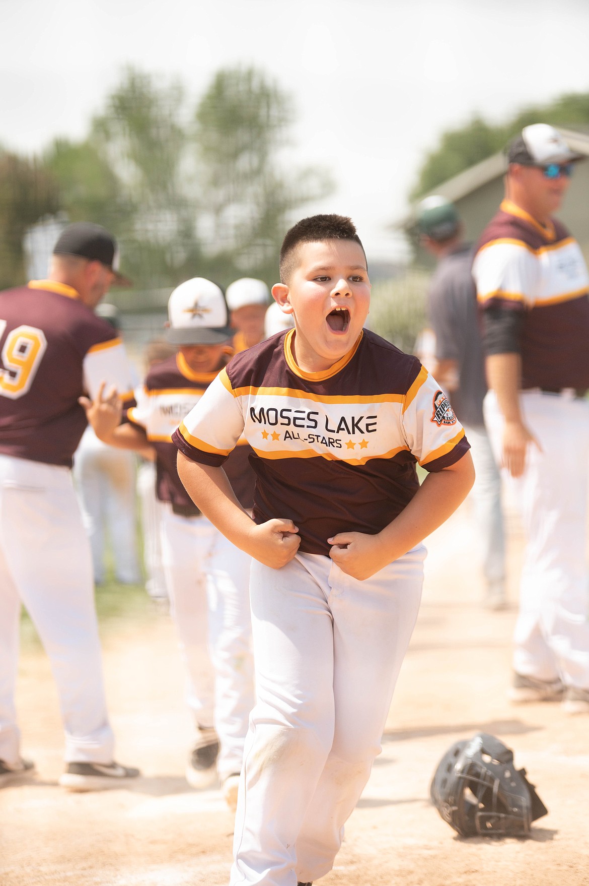 Azariah Escamilla flexes his muscles while celebrating after the Moses Lake 9U All Stars won the  Pacific Northwest Regional Cal Ripken Tournament in Meridian, Idaho, last Saturday.
