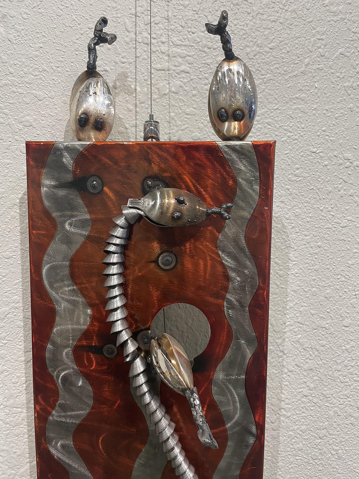 A closeup of one of Andrea Johnson’s metal sculptures featuring snakes made of spoons and flexible plumbing pipe.