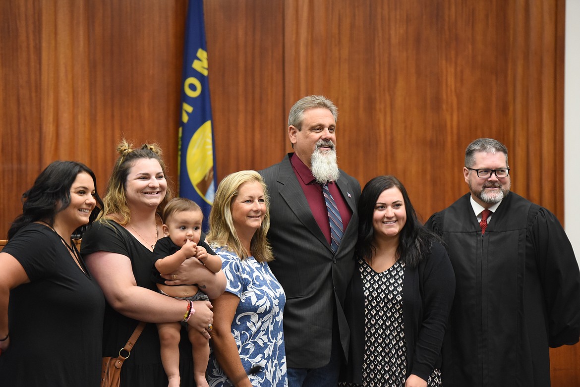 Brent Teske, former mayor of Libby, celebrates with his family and District Judge Matthew Cuffe after being sworn in as a county commissioner.