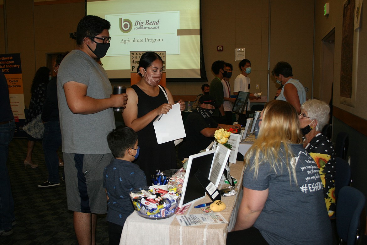 Osvaldo Zempoalteca (left) and Guadalupe Collazo (center) talk to Liz Janetos (right) and Connie Williams (far right) about employment opportunities at the summer job fair at Big Bend Community College Thursday.