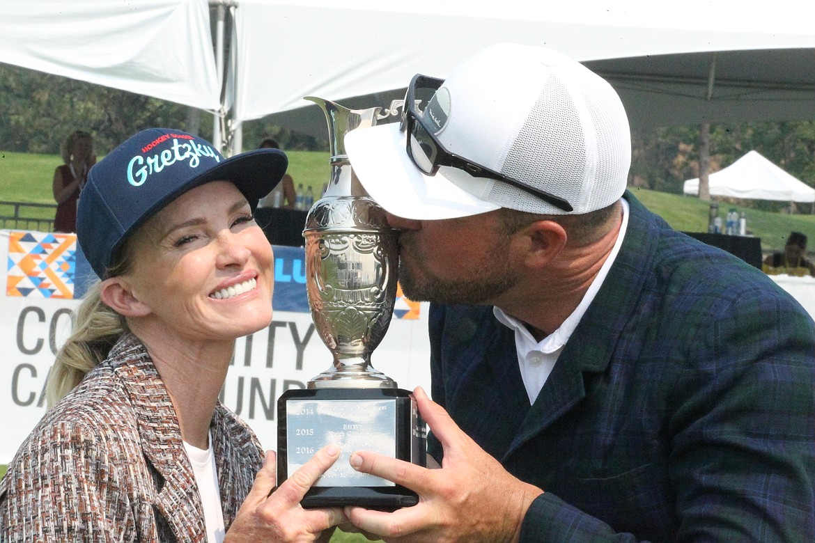 JASON ELLIOTT/Press
Janet Gretzky and Mark Mulder kiss the 2021 Showcase golf exhibition trophy after winning the seventh annual event at The Coeur d'Alene Resort Golf Course on Saturday.